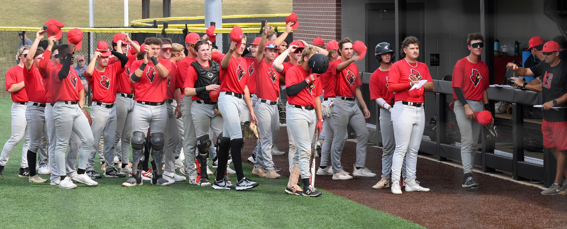 Cardinal baseball players raise their hats to Dr. Murphy in thanks for reinstating the sport